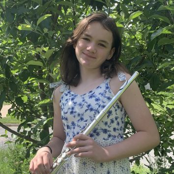 Nina Flamminio holding a flute in front of a tree